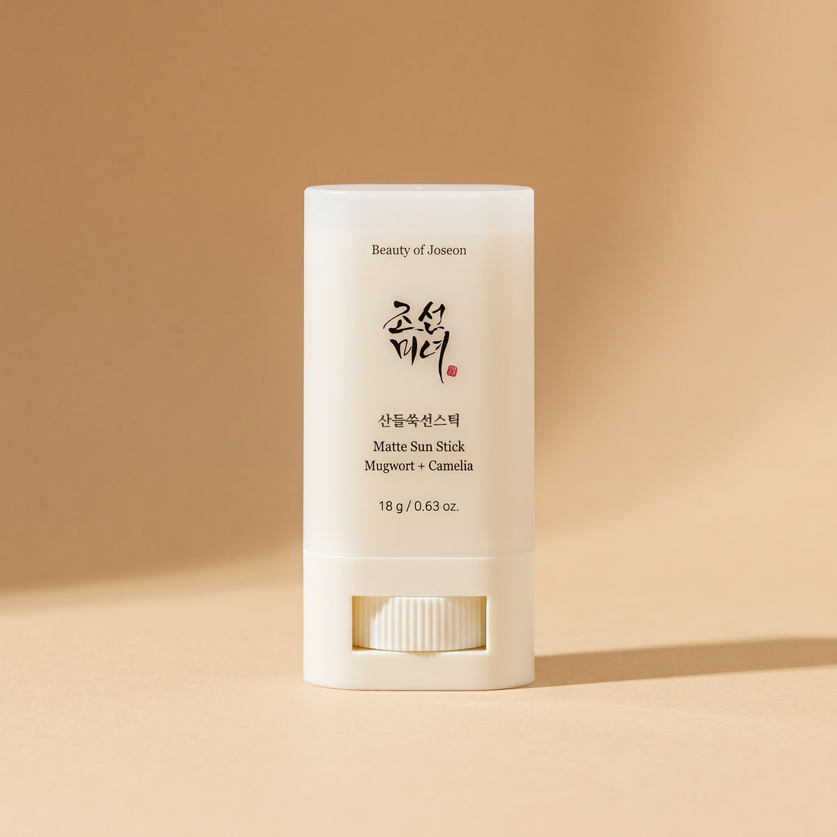 Beauty of Joseon Matte Sun Stick Mugwort + Camelia SPF 50+, 18 g, aufrecht auf sandfarbenem Hintergrund