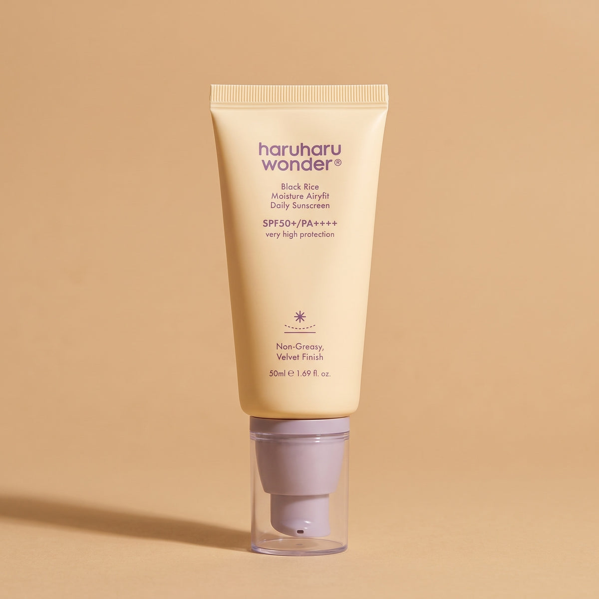 Haruharu Wonder Black Rice Airy-fit Sunscreen SPF 50+, 50 ml Tube auf sandfarbenem Hintergrund