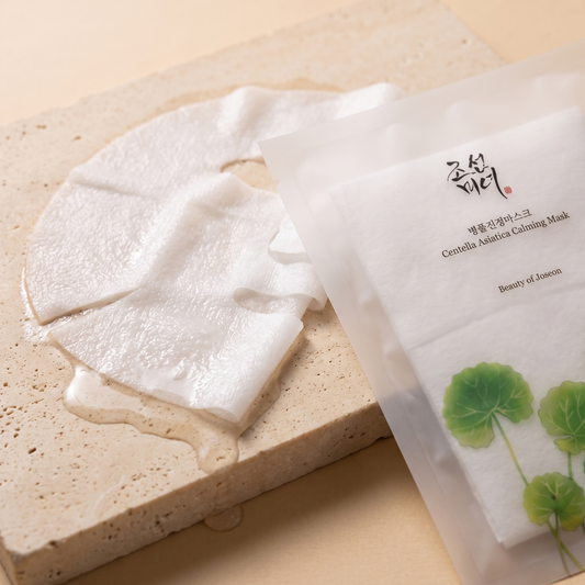 Nasses Tuch der Beauty of Joseon Centella Asiatica Maske auf hellem Stein, Sachet angeschnitten daneben
