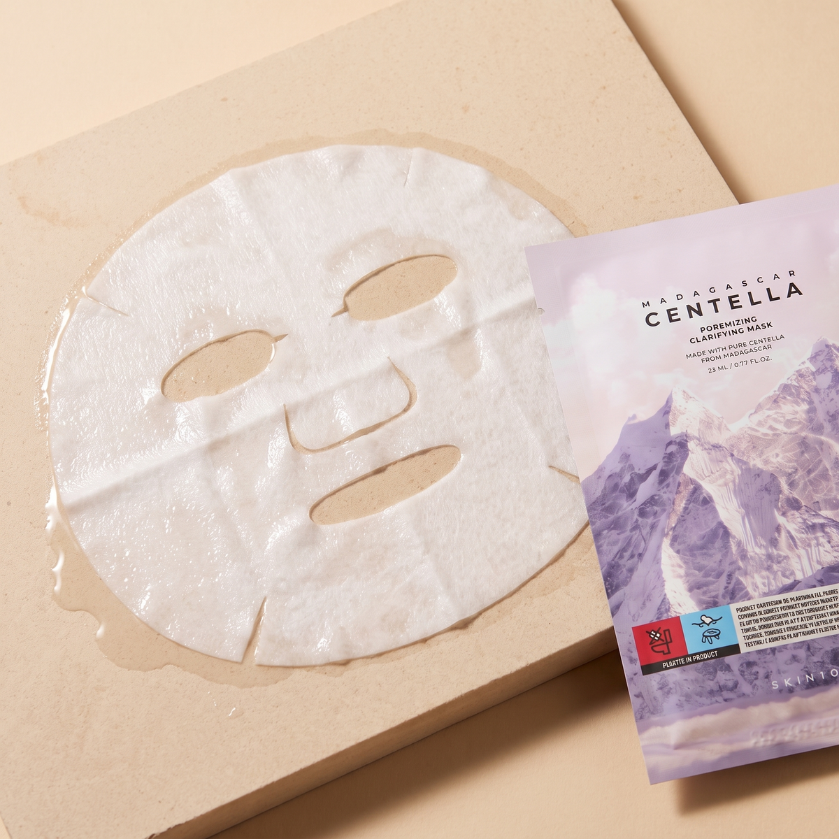 Nasses Tuch der SKIN1004 Poremizing Clarifying Mask auf hellem Stein, Sachet angeschnitten daneben