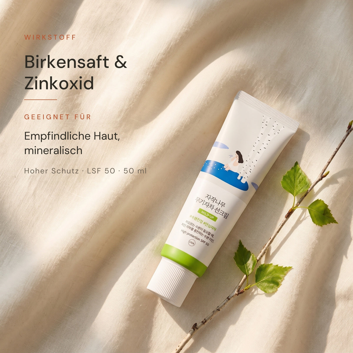 Round Lab Birch Juice Mild Up Sonnencreme auf hellem Leinen mit Birkenzweig, Hinweis auf Birkensaft und Zinkoxid